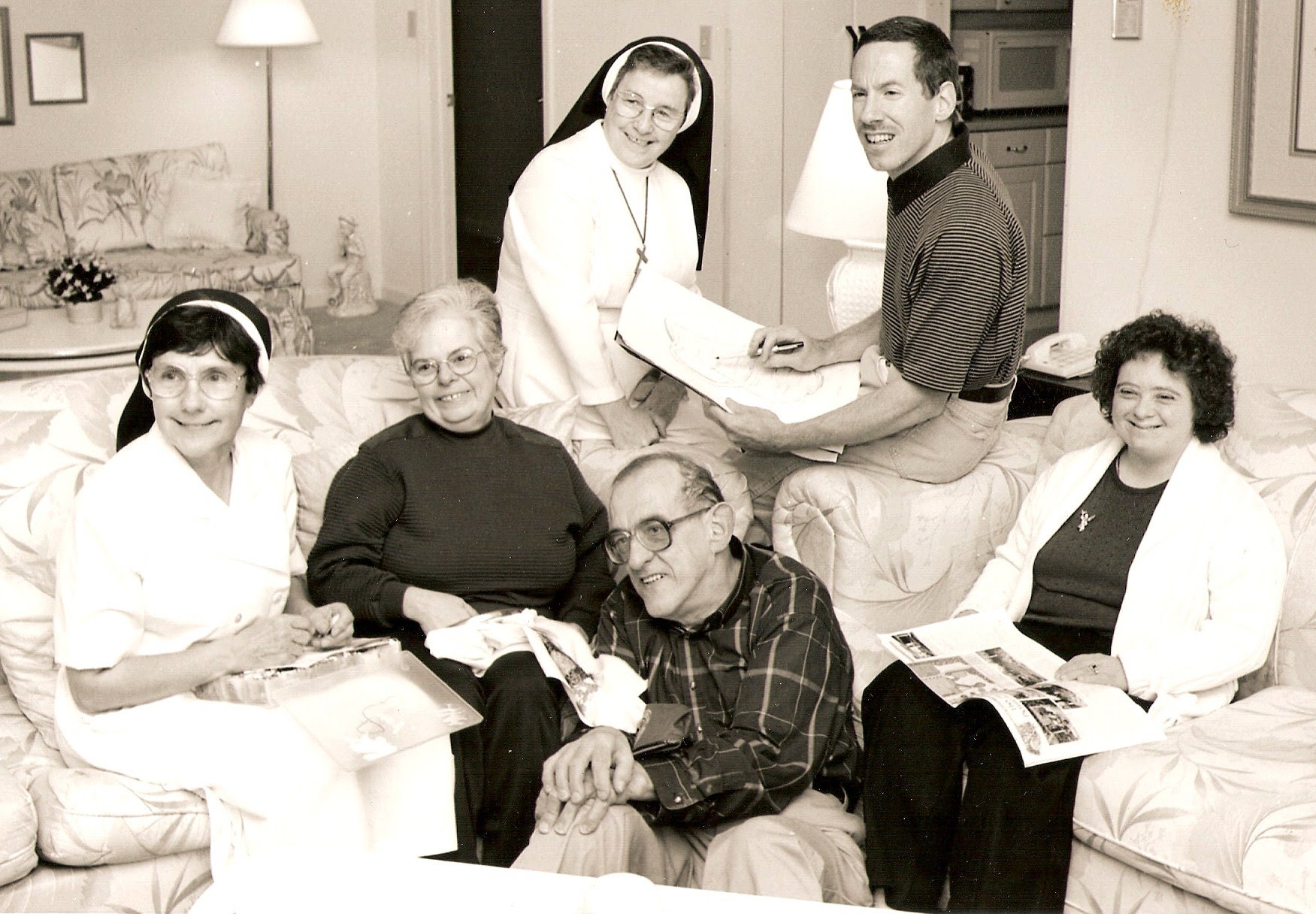 Sister Francis, residents, and volunteers in the living room